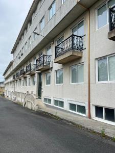 un edificio con balconi sul lato di una strada di Apartamentos Sardiñeiro a Fisterra (Finisterre)