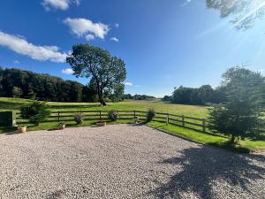 a gravel driveway with a fence and a field at Thwaite Croft - Carnforth in Carnforth