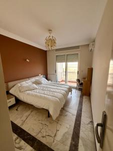 a bedroom with a large bed and a chandelier at Luxury Apartment Ocean View and Private Beach Ain Diab in Casablanca +15 photos