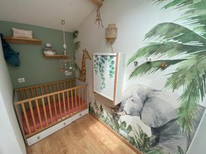 a nursery with a mural of an elephant on the wall at Nid chaleureux proche de l'océan in Lacanau