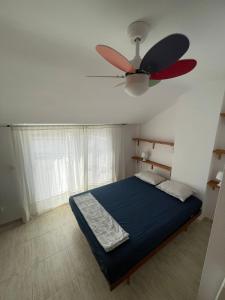 a bedroom with a ceiling fan and a blue bed at Medeea's Spanish Sunny Escape in Vinarós