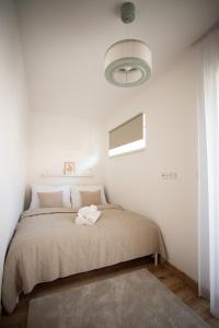 a bedroom with a large bed with a white wall at Rodinný apartmán s balkónem in Černá v Pošumaví