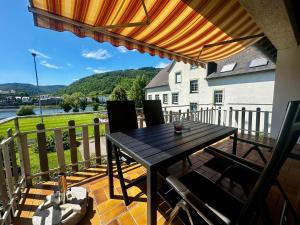 a patio with a table and chairs on a balcony at Traumaussicht Kamin Balkon Burgblick 65 Zoll TV Netflix Waipu Lindenplatz in Bullay