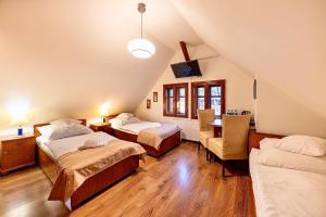 Pokój na poddaszu z 2 łóżkami, stołem i krzesłami w obiekcie REZYDENCJA MARIA Karpacz w mieście Karpacz