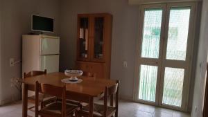 a dining room with a table and a refrigerator at San Pietro Apartments in San Pietro in Bevagna