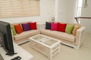 a living room with a couch with colorful pillows at Willow Way Inn Entire House in Negombo