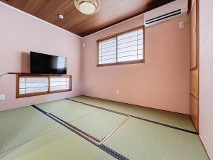 an empty room with a flat screen tv and a flat screen tv at ulu Okinawa Resort in Motobu