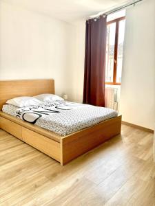 a bed in a bedroom with a wooden floor at L'appart cosy Cruas ღ au pied du château in Cruas