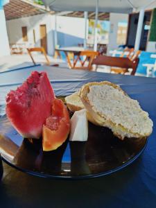 une assiette de nourriture avec des fruits et du pain sur une table dans l'établissement Pousada Areias do Mutá, à Porto Seguro