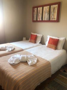 two beds with towels on top of them at Casas Sebastião - Tourist House in Caminha