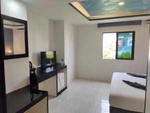 a hotel room with a bed and a mirror at Chilli House Residence in Patong Beach