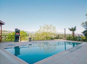 a swimming pool with blue water and a fence at Luxury Villas in Kireçhane