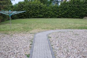 a brick walkway in a yard with a grass field at Appartmenthaus Zum Goldstern Monteurswohnung in Staßfurt
