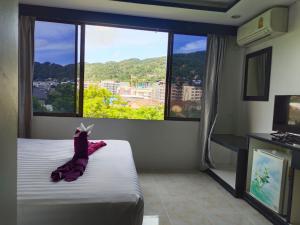 a hotel room with a bed and a large window at Chilli House Residence in Patong Beach
