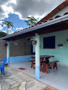 a patio with two picnic tables and a roof at Recanto Boa Vista in Pirenópolis