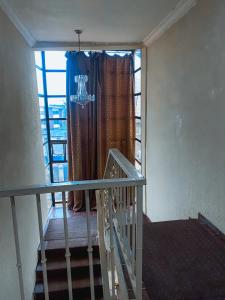 OkunolaLa View Suites And Towers的通往带蓝色窗帘的窗户的楼梯 更多10张照片