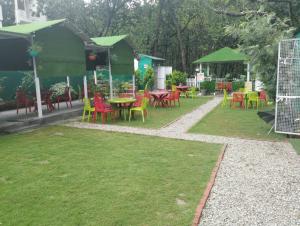 a group of tables and chairs in a park at Guruji Homestay Near UPES Collage in Jhājra