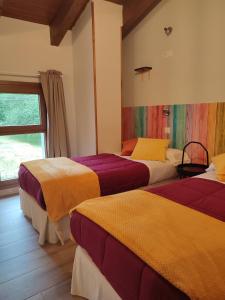 a hotel room with two beds and a window at El Campo de Petra in Grado