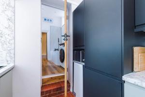 a kitchen with blue cabinets and a washer and dryer at Cozy 3-Bed Home by 53 Degrees Property, Perfect for Business & Groups! in Leek +30 photos