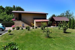 a house with a yard with trees in front of it at Domek pod Zatorem in Ryczów