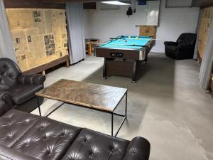 a living room with a pool table and leather couches at m i g l i o r e in Pargas