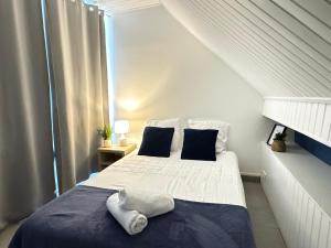 a bedroom with a bed with blue and white sheets at Appartement Platanes 6 - Proche Disney - Parking Gratuit - Meaux in Meaux