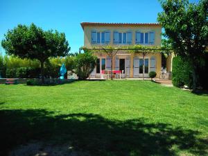 a house with a large lawn in front of it at Maison villa avec piscine et spa, 8 à 10 personnes in LʼIsle-sur-la-Sorgue