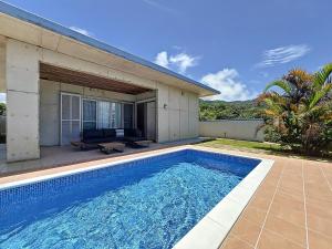 a swimming pool in front of a house at ulu Okinawa Resort in Motobu
