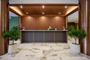 a woman sitting at a desk in a lobby at Elite Luxury Hotel by Elite24 in Danang