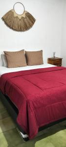 a bedroom with a bed with a red blanket at Rumah Sedana Ubud Centre in Ubud