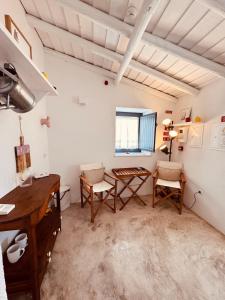 a room with a table and chairs and a desk at Casinha do Largo - Casas da Amieira in Amieira