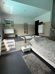 Un dormitorio con una cama, un lavabo y una bañera. en Atypical loft with private pool, en Le Lavandou 56 fotos más