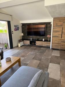 Una sala de estar con un televisor de pantalla plana grande. en Atypical loft with private pool, en Le Lavandou