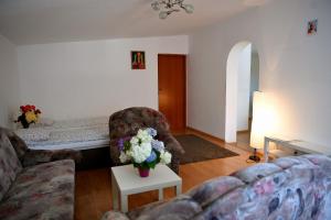 a living room with a couch and flowers on a table at Domek pod Zatorem in Ryczów
