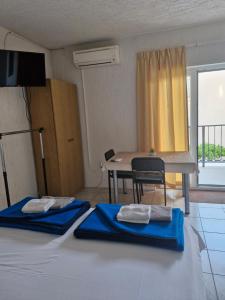 two beds in a room with a table and a dining room at Apartmani Džapo in Srima