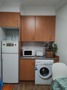 a kitchen with a white refrigerator and a microwave at Arenal confort in Marín +13 photos