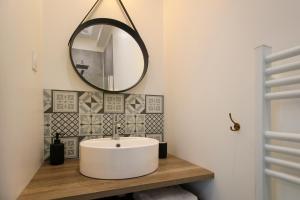 a bathroom with a white sink and a mirror at Appartement avec terrasse in Luçon +4 photos