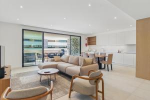 ラゴスにあるCasaLuxo New 2BR Pool Viewのソファと椅子、キッチンのあるリビングルーム