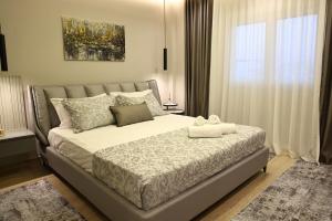 a bedroom with a large bed and a window at Nova Luxury Apartment in Durrës