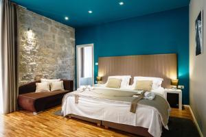 een grote slaapkamer met een groot bed en een bank bij Riva Luxury Rooms in Split