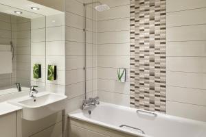 a bathroom with a sink and a tub and a mirror at Premier Inn Dublin City The Liberties in Dublin +19 photos