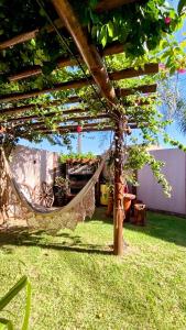 a hammock hanging from a pergola in a yard at Casa Rústica com piscina in Cascavel
