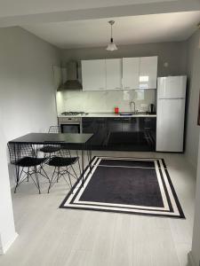 a kitchen with a table and chairs and a refrigerator at Özçelik Apart in Çaykara