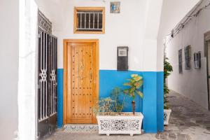 a blue and white building with a wooden door at Chambre au cœur de la médina avec salle de bain privé in Tangier