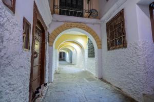 an alley with an archway in a building at Chambre au cœur de la médina avec salle de bain privé in Tangier