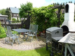 a patio with a grill and a table and chairs at Ferienwohnung-Kubis in Kurort Altenberg