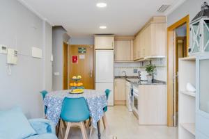 a small kitchen and dining room with a table and chairs at Chillout Grau de Gandia- attico para 6 personas dos banos VT-44956-V in Gandía