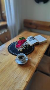 a table with a cup of coffee and a book at Zacisze in Kościelisko