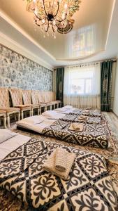 two beds in a bedroom with a chandelier at Guest House Ormon in Ak-Muz