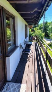 a porch with a table and chairs on a building at Zacisze in Kościelisko